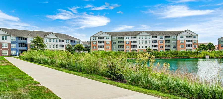 Lakeside exterior with walking trail and pond on a bright sunny day